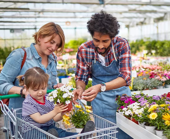 Mother and daughter being helped by a greenhouse employee