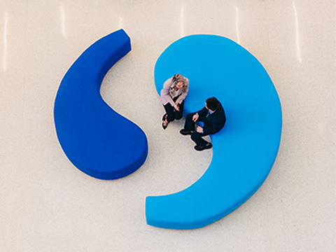Aerial view of two people talking on the quote couches at the Division Street office.