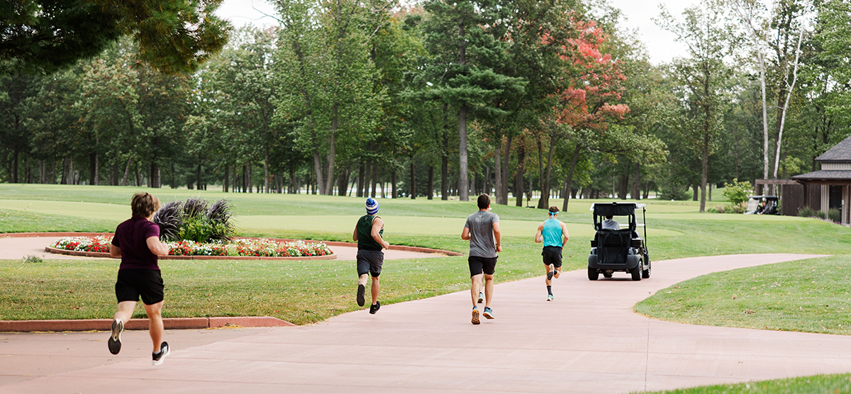 Runners leading the close the course race down the golf cart path. 