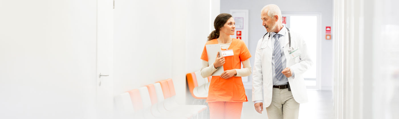 Two medical professionals walking and talking.