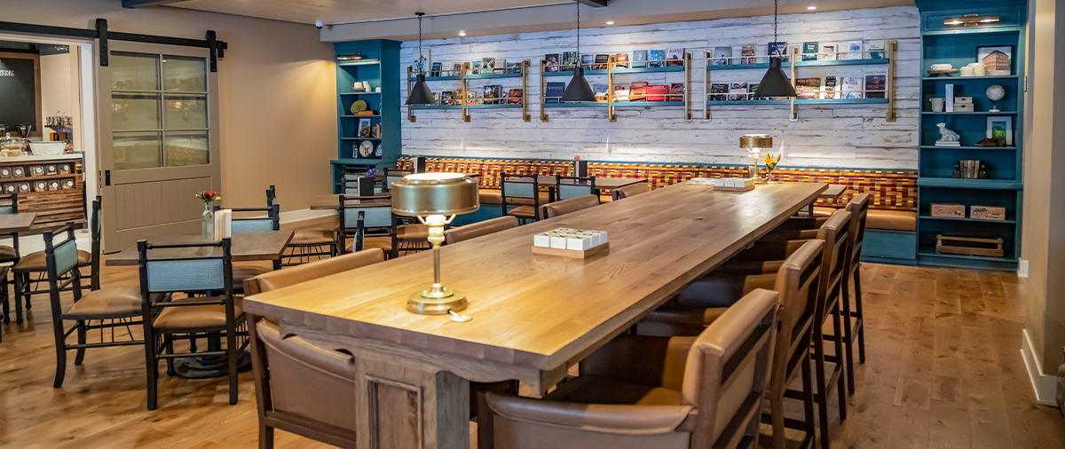 Long table with lamps and chairs and other tables in the Library Cafe