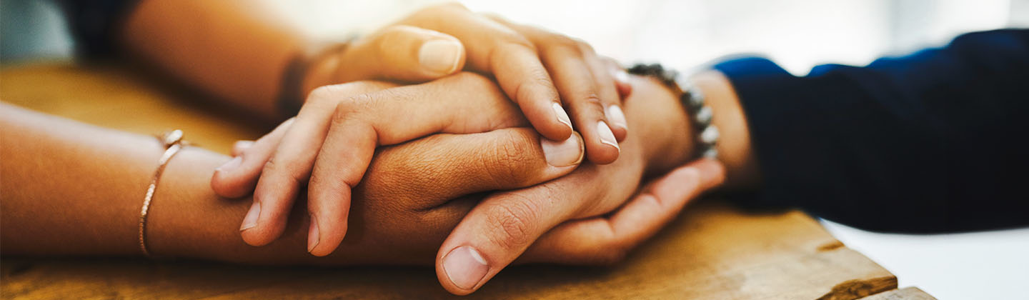 Close up of two people's hands holding one another