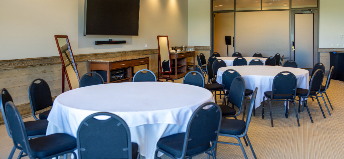 Three round tables with chairs and mirrors in the community room.