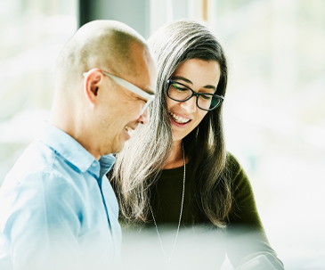 Two business people in glasses smiling