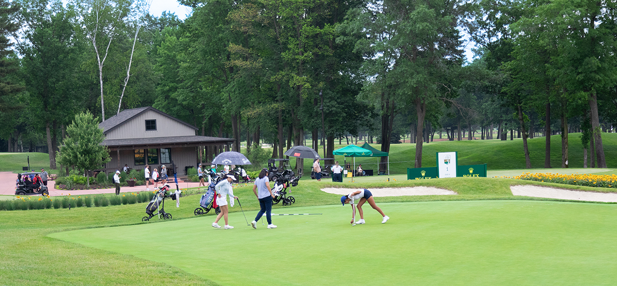 Junior golfers putting on hole 16. 