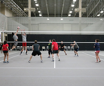 People playing volleyball in the fieldhouse at SentryWorld