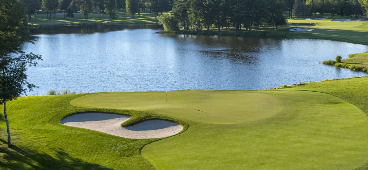 Golf green with lake behind. 