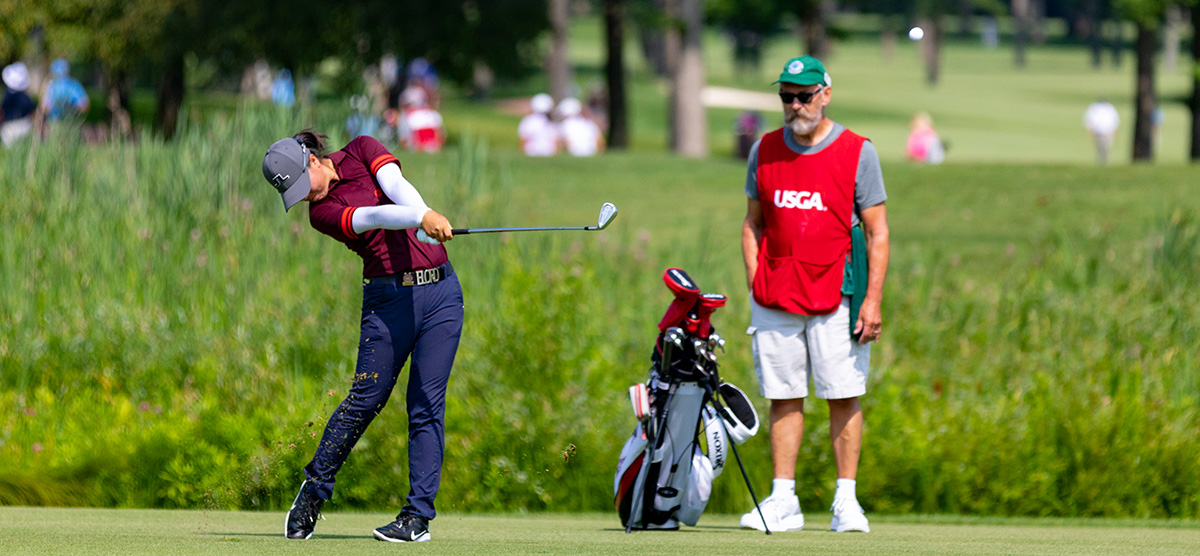 Yuka Saso swinging with her caddy at the USGA championship at SentryWorld