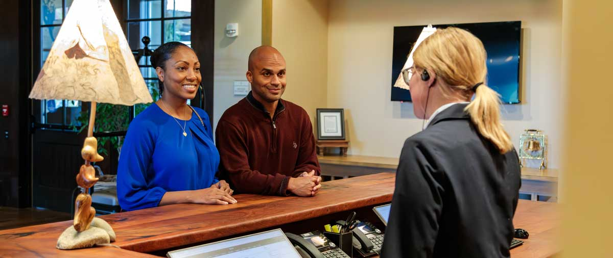 Two customers talking with a front desk employee at The Inn at SentryWorld