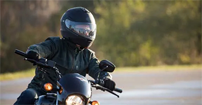 Motorcycle rider wearing leather jacket, glove and helmet