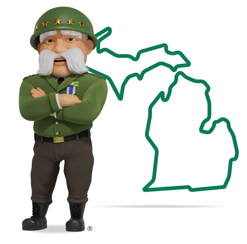 The General standing in front of Michigan with his arms crossed and a smile.