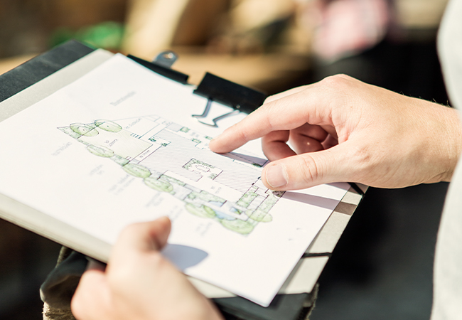 Hands pointing at a property map on a clipboard