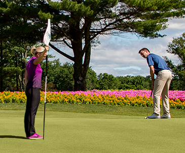 Two players putting on the 16th hole green at SentryWorld