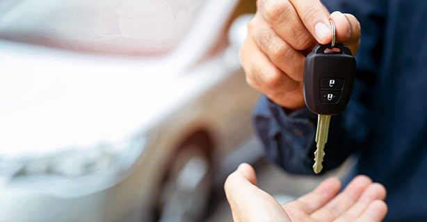 Man handing car keys to someone else