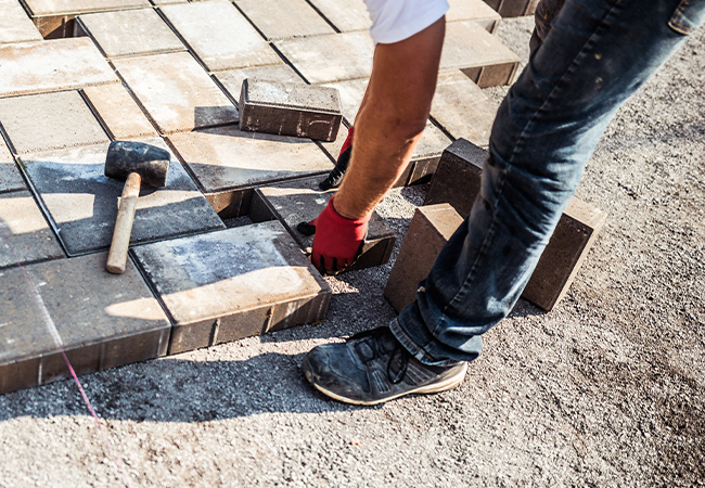 Someone laying patio bricks