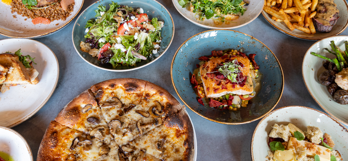 Pizza and other dishes at PJ's laid out on a table