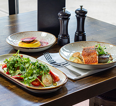 Salad, salmon, and dessert plates on a table. 
