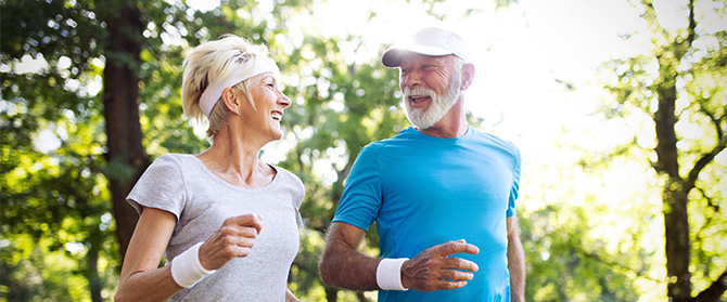 Two older people running outside together