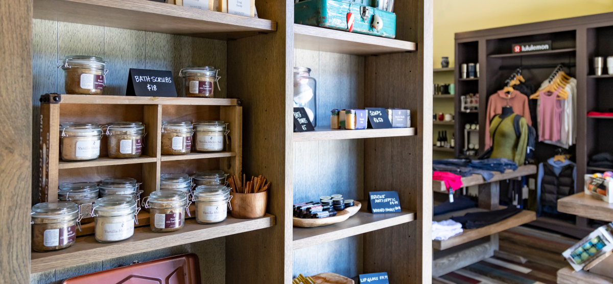 Shelves filled with bath scrubs and soaps, next to a display of Lululemon clothing.