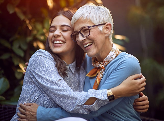an older woman hugging a younger woman