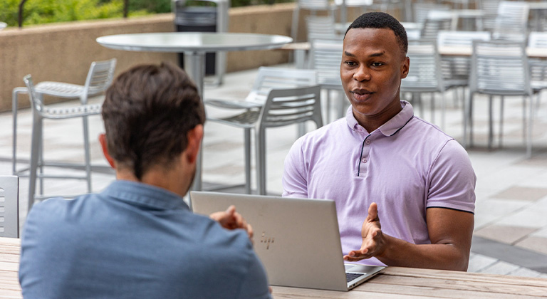 A Sentry intern having a conversation on the patio at the Sentry Insurance home office in Stevens Point.