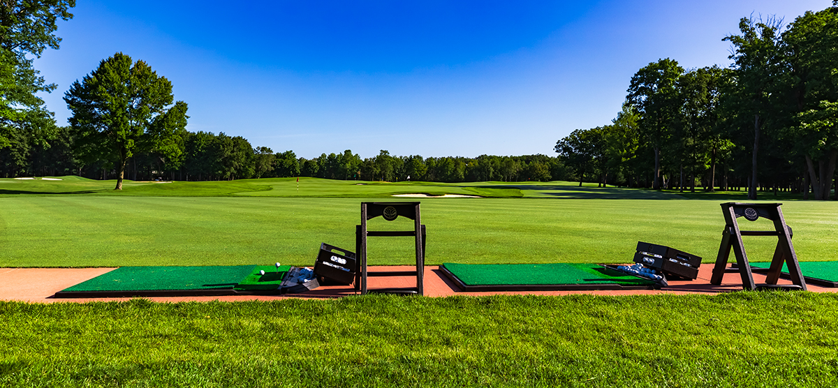 Practice mats and two buckets of golf balls at the outdoor SentryWorld driving range