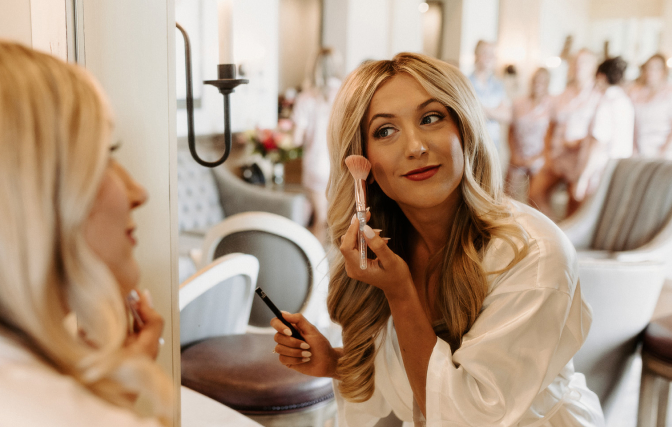Woman putting on make-up in the SentryWorld salon room. 