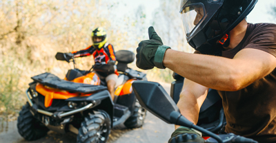 ATV rider gives thumbs up to other ATV rider.