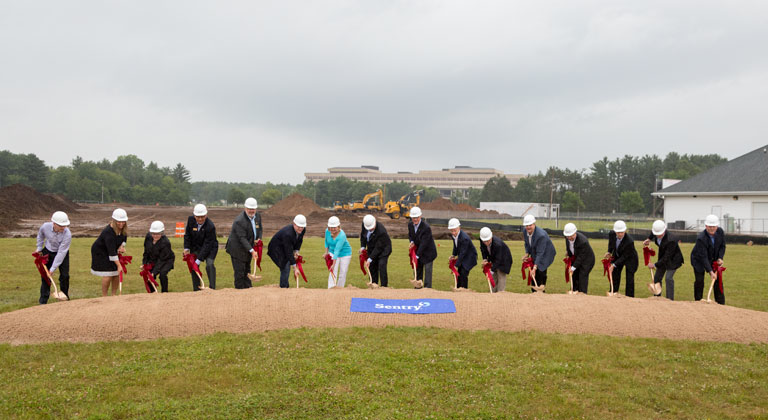 Group of people doing a ceremonial groundbreaking for new Sentry building