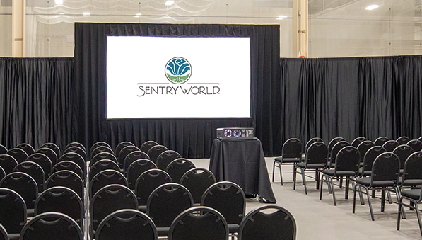 SentryWorld Fieldhouse projector screen and seating for a corporate meeting