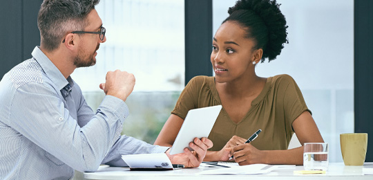 Two people sitting at a desk and taking