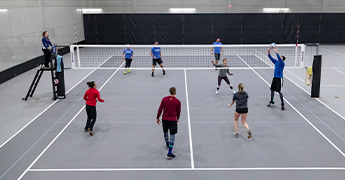 People playing volleyball in the SentryWorld fieldhouse