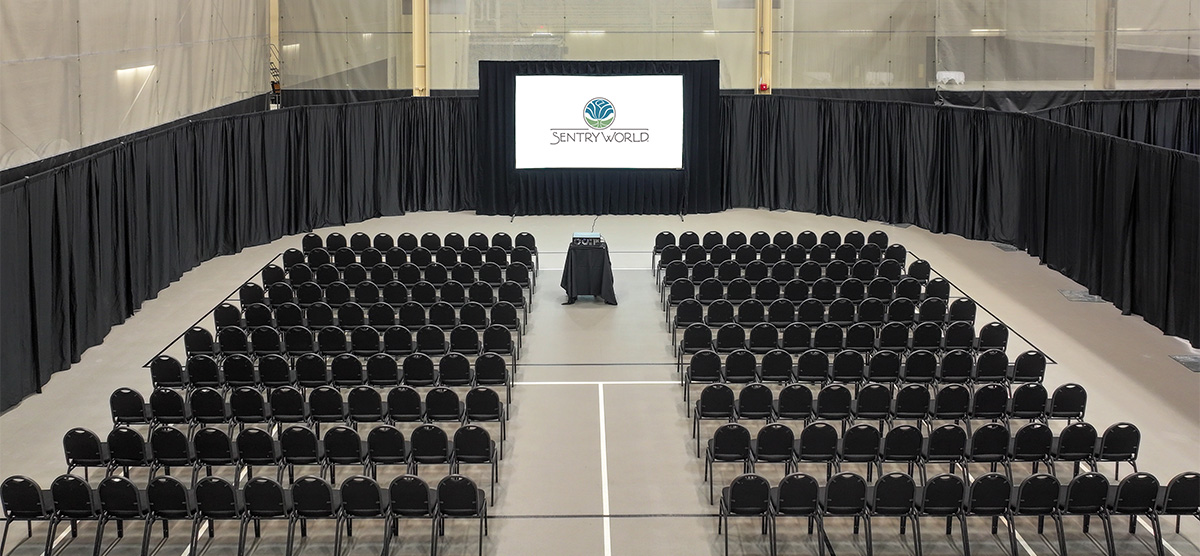 Aerial view of chairs and a projector screen set for an event in the fieldhouse at SentryWorld