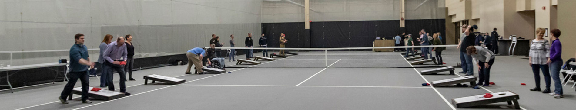 Teams playing a game of bean bag toss on the courts in the SentryWorld fieldhouse