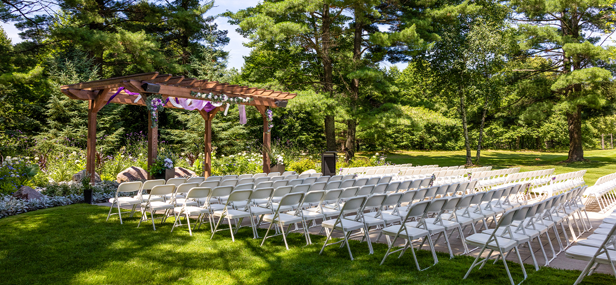 carousel-wedding-venue-pergola-2-1200x556 Pergola set up with white chairs for a wedding.