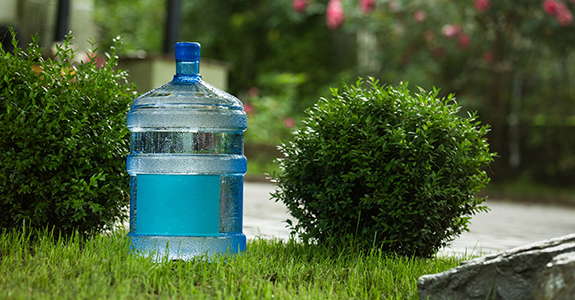 A water jug sitting on grass