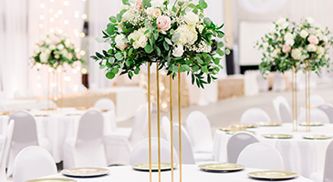 Floral center pieces on wedding reception tables in the SentryWorld fieldhouse