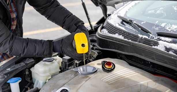 Man pouring oil into engine bay