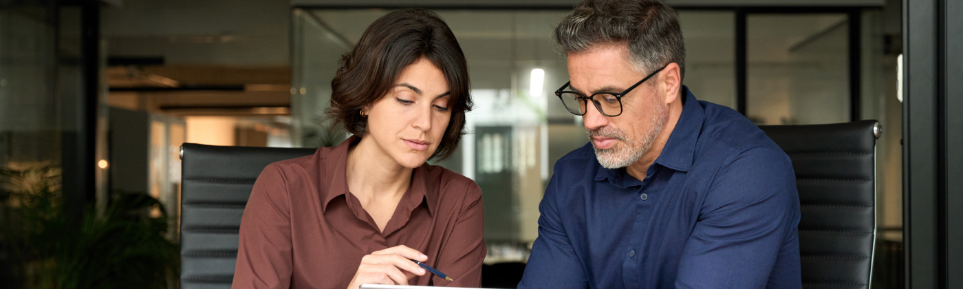 Two people reviewing information on tablet.
