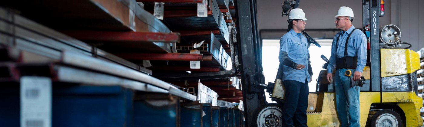 Two warehouse workers talking to each other.