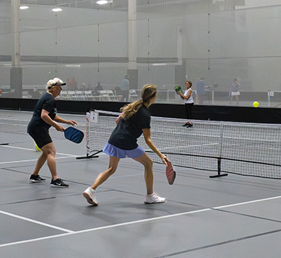 hero-pickleball-open-qaulifier-2-396x364 Games of pickleball being played in the SentryWorld field house.