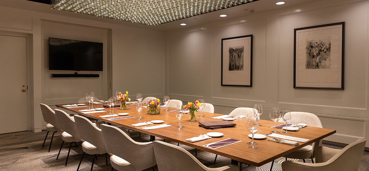 Private dining table set and a TV on the wall in the Private Dining Room at Muse