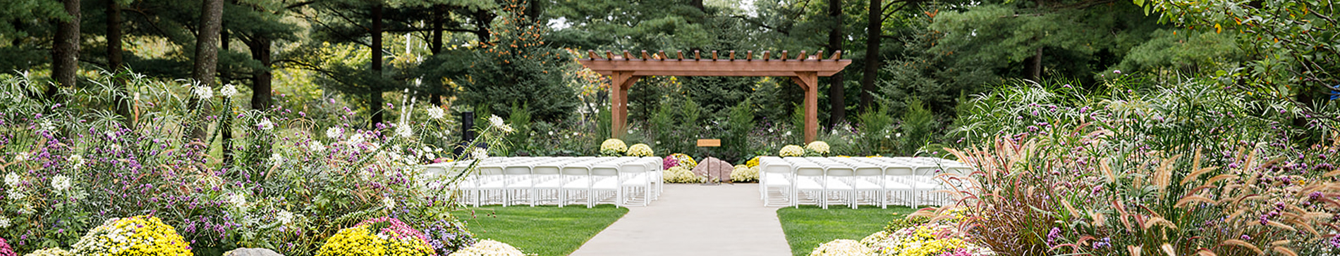 Chairs and flowers along the aisle leading to the outdoor pergola at SentryWorld