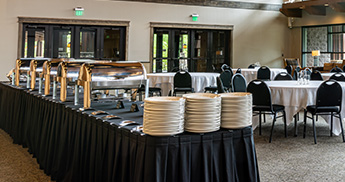 Catering station and round tables set up in the Atrium at SentryWorld