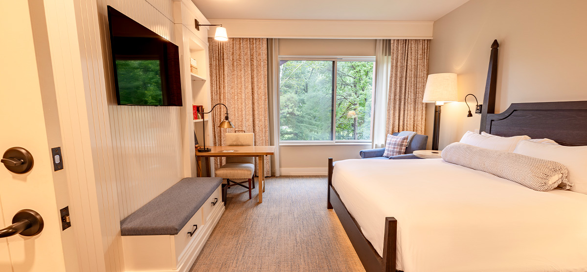 carousel-executive-king-suite-2br-4-1200x556 Bedroom with a king sized bed and desk.