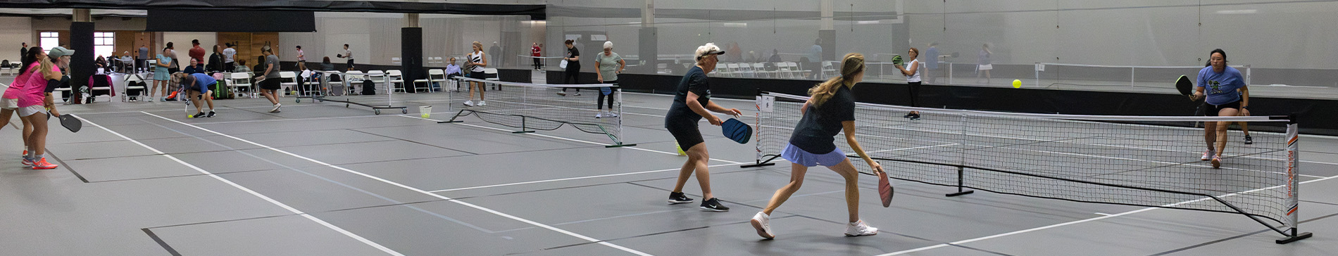 hero-pickleball-open-qaulifier-2-1900x364 Games of pickleball being played in the SentryWorld field house.