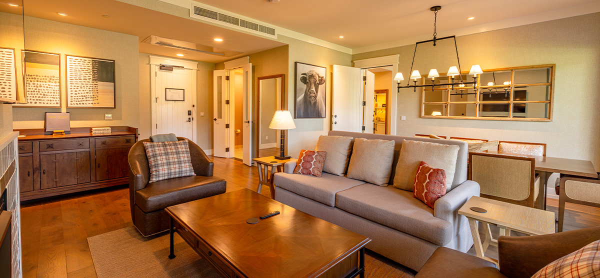 carousel-accessible-golf-view-king-suite-5-1200x556 Suite parlor room with a dining room table and seating area.