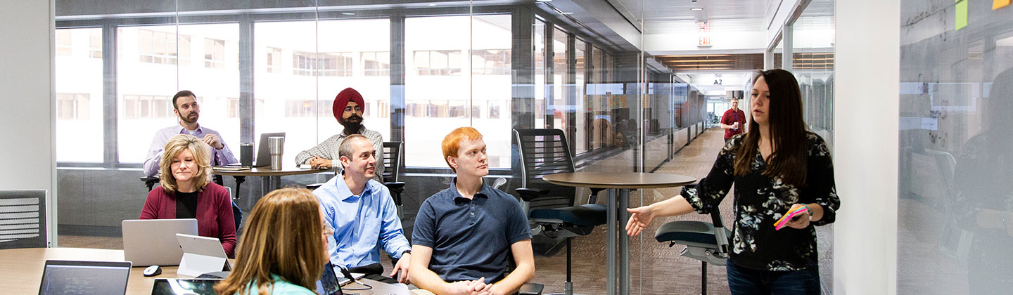 Seven people meeting in a Sentry office room