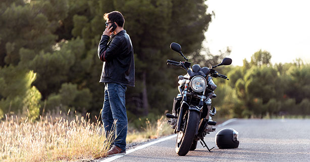 Motorcyclist using a phone on the side of the road