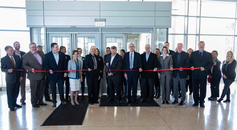 Pete McPartland cutting ribbon for new Sentry building with Tony Evers